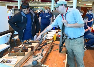 Daniel Chasse, historic preservation instructor, explains the various tools used in carpentry to Juan Aguilar, a tenth grader at SouthWest Edgecombe High School, during last night’s Career Clusters Showcase at Edgecombe Community College.