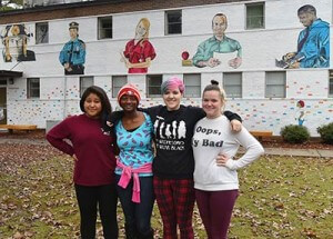From left, Edgecombe Early College High School students Maria Mosso, Jo’Mya Tillery, Katy Williamson, and Taylor Joyner stand in front of a mural they painted at Edgecombe Community College that represents the various careers for which students can prepare at ECC.