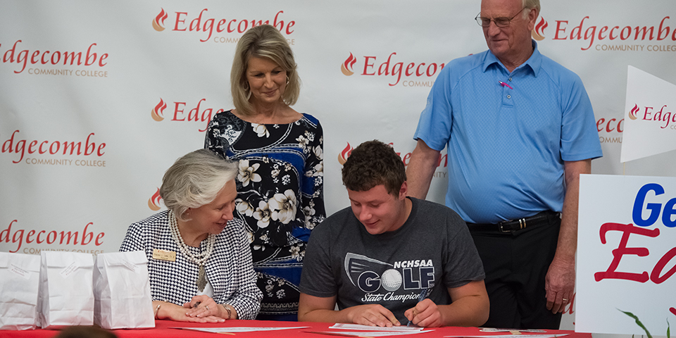 Edgecombe Community College President Dr. Deborah Lamm watches as Zachary Wainwright, a senior at SouthWest Edgecombe High School, signs a certificate of commitment to attend ECC this fall. Standing are Wainwright’s grandparents, Barbara and Glenn Warren.