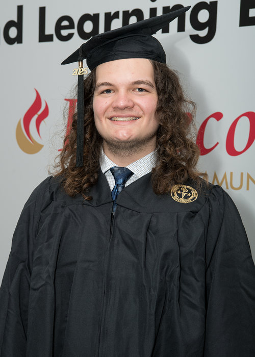 Smiling white male with long brown hair wearing cap and gown