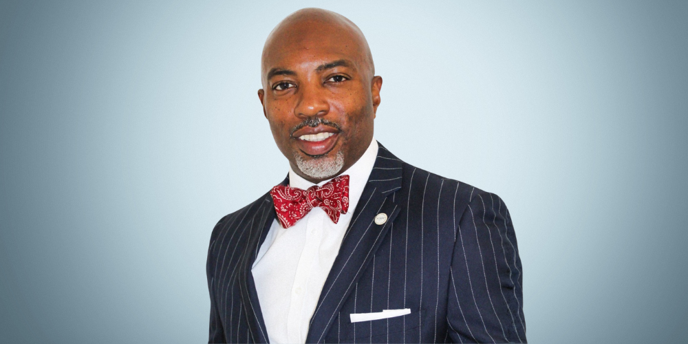 Portrait of a man wearing a pinstripe suit and bowtie.